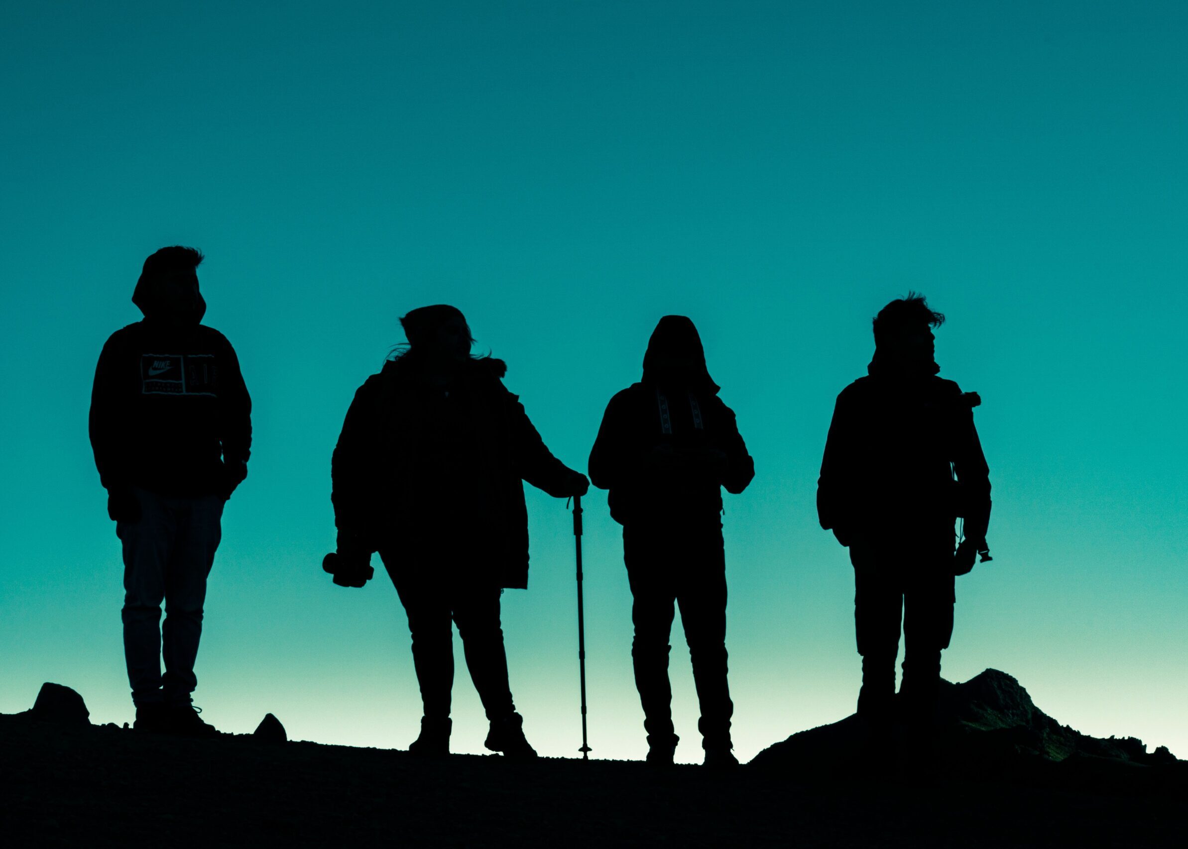 A group of silhouetted hikers against a sunset sky in Toluca de Lerdo, Mexico, creating a stunning outdoor scene.